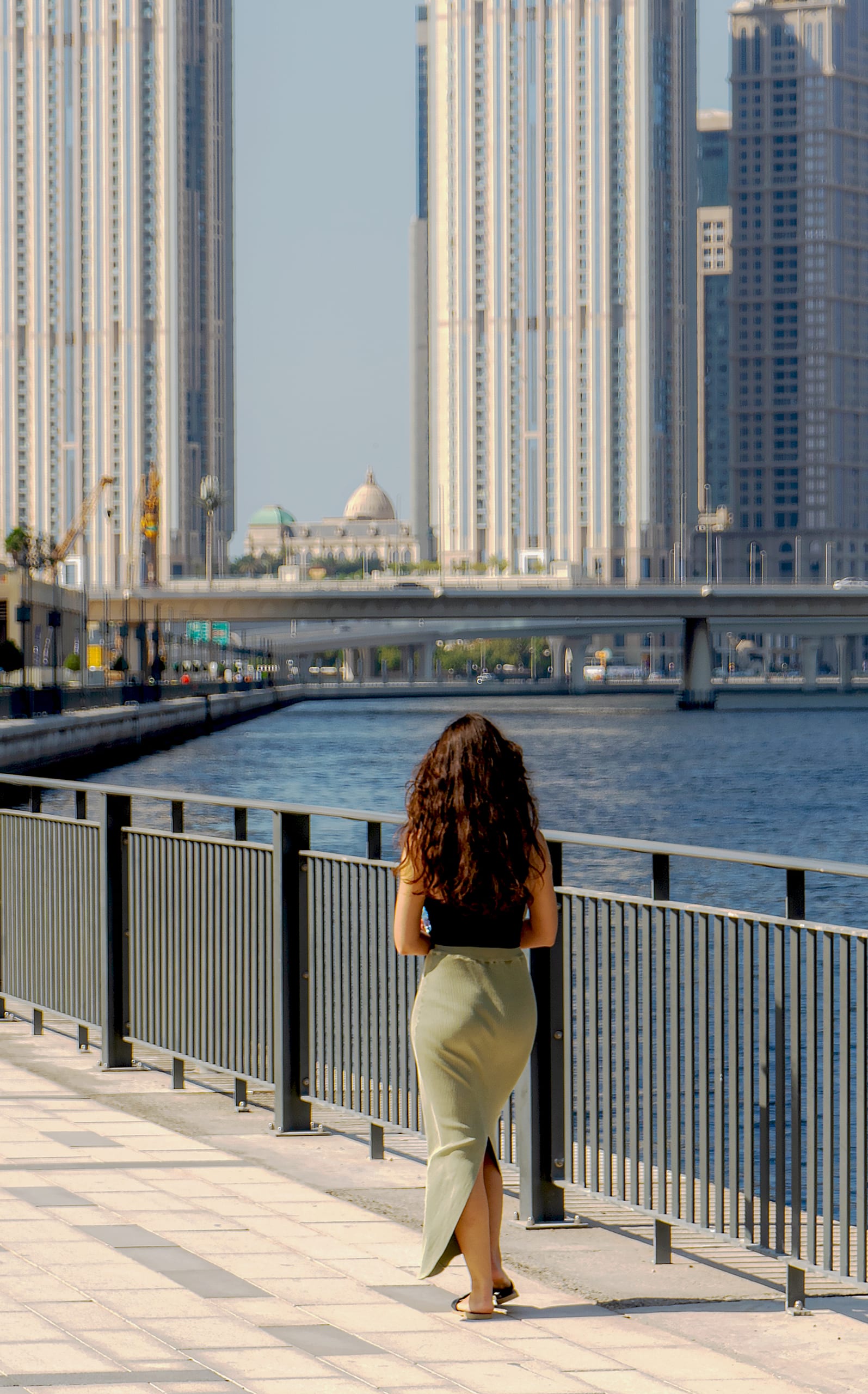 Girl Walking SEA Building, a fine-art photograph by Ali Abu Ras